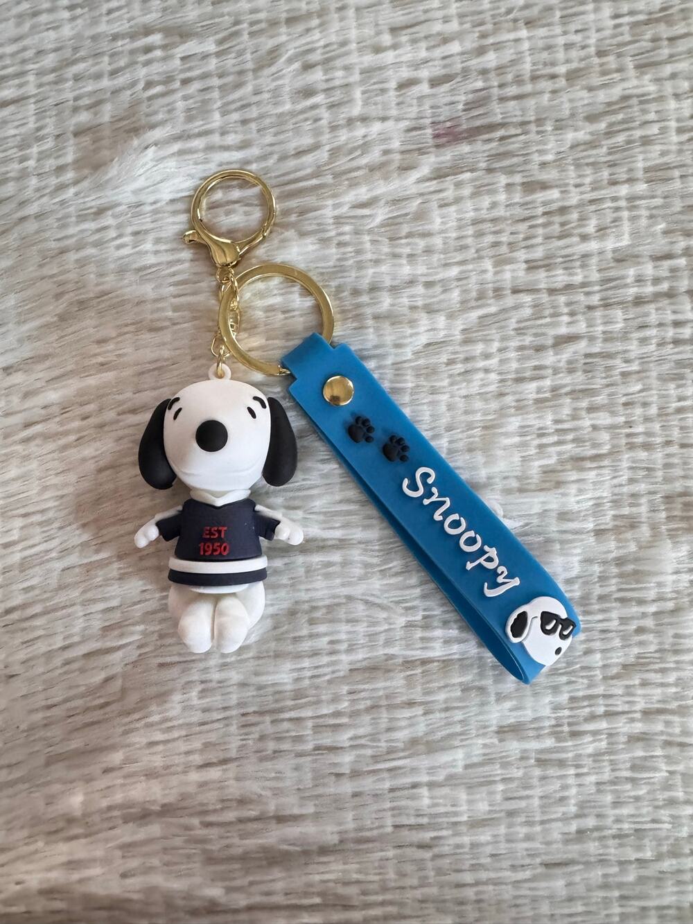 Snoopy with sweater keychain blue strap featuring white text and Snoopy graphic